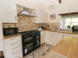 A kitchen with cabinets and appliances at Granary Cottage in Clarbeston Road