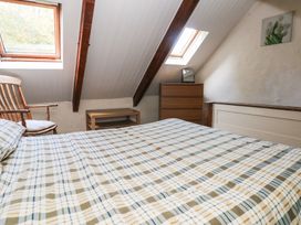 A bedroom with a bed and furniture at Granary Cottage in Clarbeston Road