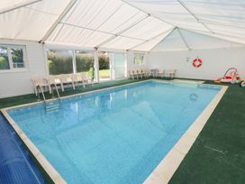 An indoor pool with chairs and a life buoy at Granary Cottage in Clarbeston Road