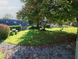 A garden with a tree and a picnic table at Granary Cottage in Clarbeston Road