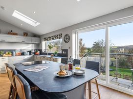 A kitchen with dining table and stools at Newlands in Yelverton