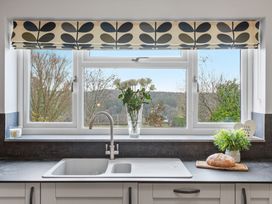 A kitchen with a sink and flowers by the window at Newlands Yelverton