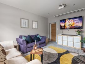 A living room with a sofa and TV at Newlands in Yelverton