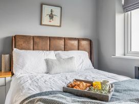 A bedroom with a bed and a tray with drinks and croissants at Newlands Yelverton