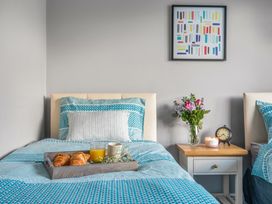 A bedroom with two beds and a tray of breakfast items at Newlands in Yelverton