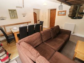 A living room with a sofa and dining table at Rafters Cottage in Clarbeston Road
