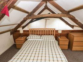 A bedroom with a bed and bedside tables at Rafters Cottage in Clarbeston Road
