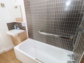 A bathroom with a bathtub and sink at Rafters Cottage in Clarbeston Road