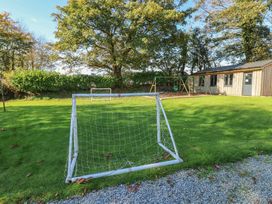 An outdoor area with a soccer goal, swing set, and a building at Rafters Cottage in Clarbeston Road