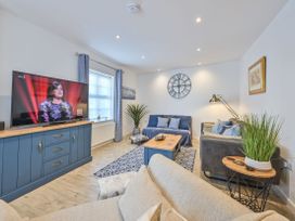 A living room with a television, sofa, and coffee table at Number 2 Ellington Court Apartment in Torquay