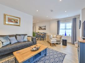 A living room with a sofa, coffee table and dining table at Number 2 Ellington Court Apartment in Torquay