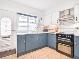 A kitchen with cabinets and appliances at Number 2 Ellington Court Apartment in Torquay