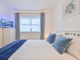 A bedroom with a bed, television and dresser at Number 2 Ellington Court Apartment, Torquay