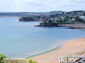A beach with sand and cliffs at Number 2 Ellington Court Apartment in Torquay