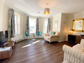 A living room with a television and sofa at Ockedon House Apartment A in Torquay