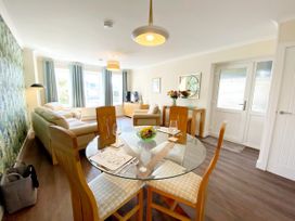 A living room with a sofa and dining table at Ockendon House Apartment B Torquay