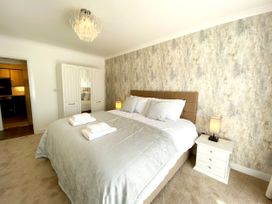 A bedroom with a bed and wardrobe at Ockendon House Apartment B Torquay