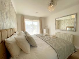 A bedroom with a bed and mirror at Ockendon House Apartment B in Torquay