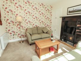 A living room with a sofa, coffee table and fireplace at East View in Ravenstonedale near Kirkby Stephen