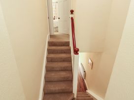 A staircase with a handrail and a door at East View Ravenstonedale near Kirkby Stephen