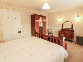A bedroom with a bed and wardrobe at East View in Ravenstonedale near Kirkby Stephen