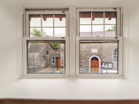 A window view showing a door and stone buildings at East View in Ravenstonedale near Kirkby Stephen