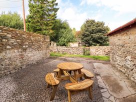 An outdoor area with a wooden table and benches at East View in Ravenstonedale near Kirkby Stephen