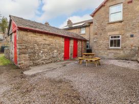 An outdoor area with a stone building and table seating at East View in Ravenstonedale near Kirkby Stephen
