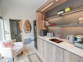 A kitchen with cabinets, sink, and appliances at Cabin At The Brig Annan