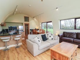 A living room with a sofa and dining area at The Rookery in Rosslare Harbour, County Wexford