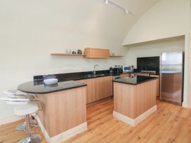 A kitchen with wooden cabinets and appliances at The Rookery in Rosslare Harbour, County Wexford