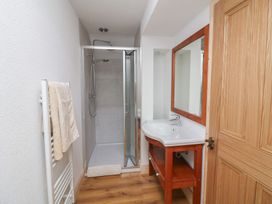 A bathroom with a shower, sink, and mirror at The Rookery in Rosslare Harbour, County Wexford