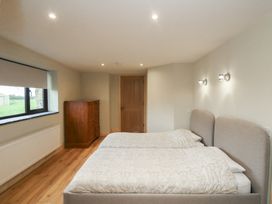 A bedroom with two beds and a dresser at The Rookery in Rosslare Harbour, County Wexford