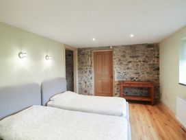 A bedroom with two beds and a wooden table at The Rookery in Rosslare Harbour, County Wexford