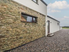 An exterior view of a house with a stone wall and gravel pathway at The Rookery Rosslare Harbour, County Wexford