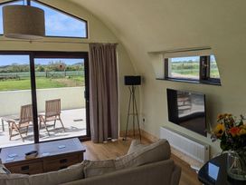 A living room with a sofa and television at The Rookery in Rosslare Harbour, County Wexford