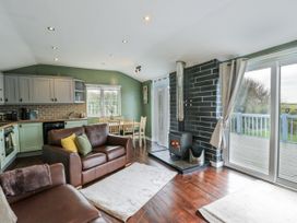 A living room with a sofa and dining area at Harbour Lights in Holyhead