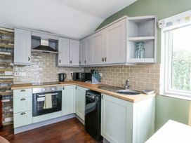 A kitchen with cabinets and appliances at Harbour Lights in Holyhead