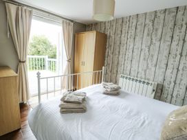 A bedroom with a bed and wardrobe at Harbour Lights in Holyhead