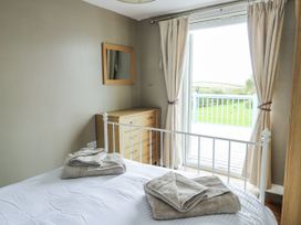 A bedroom with a bed and dresser at Harbour Lights in Holyhead