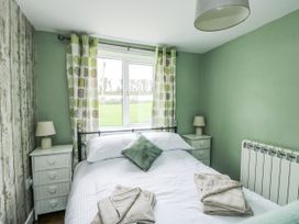 A bedroom with a bed and window at Harbour Lights in Holyhead