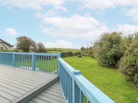 A deck overlooking a grassy area and bushes at Harbour Lights in Holyhead