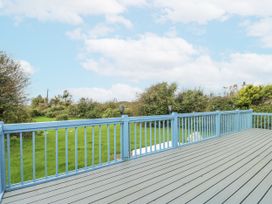 A deck with blue railing and green grass at Harbour Lights in Holyhead