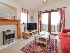 A living room with a fireplace and television at Ocean Terrace 28 in Ilfracombe