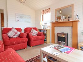 A living room with armchairs and a fireplace at Ocean Terrace 28 Ilfracombe