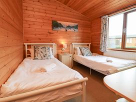 A bedroom with two beds and a table at Ocean Terrace 28 in Ilfracombe
