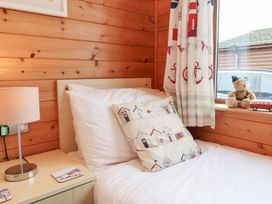 A bedroom with a bed and lamp at Ocean Terrace 28 in Ilfracombe