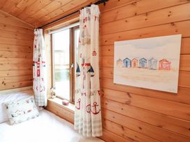 A bedroom with wooden walls and a window at Ocean Terrace 28 Ilfracombe