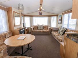A living room with a coffee table and sofas at Hideaway Lodge in Abergele