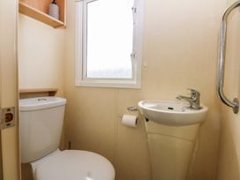 A bathroom with a toilet and sink at Hideaway Lodge in Abergele